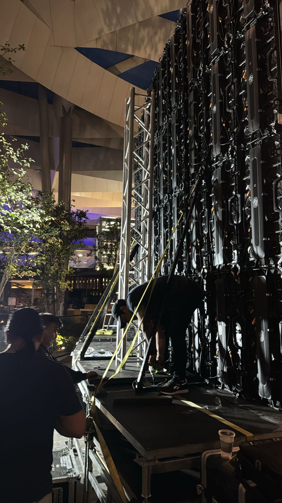 Técnicos de VideoDesign asegurando con amarres la estructura trasera del muro LED durante el montaje nocturno