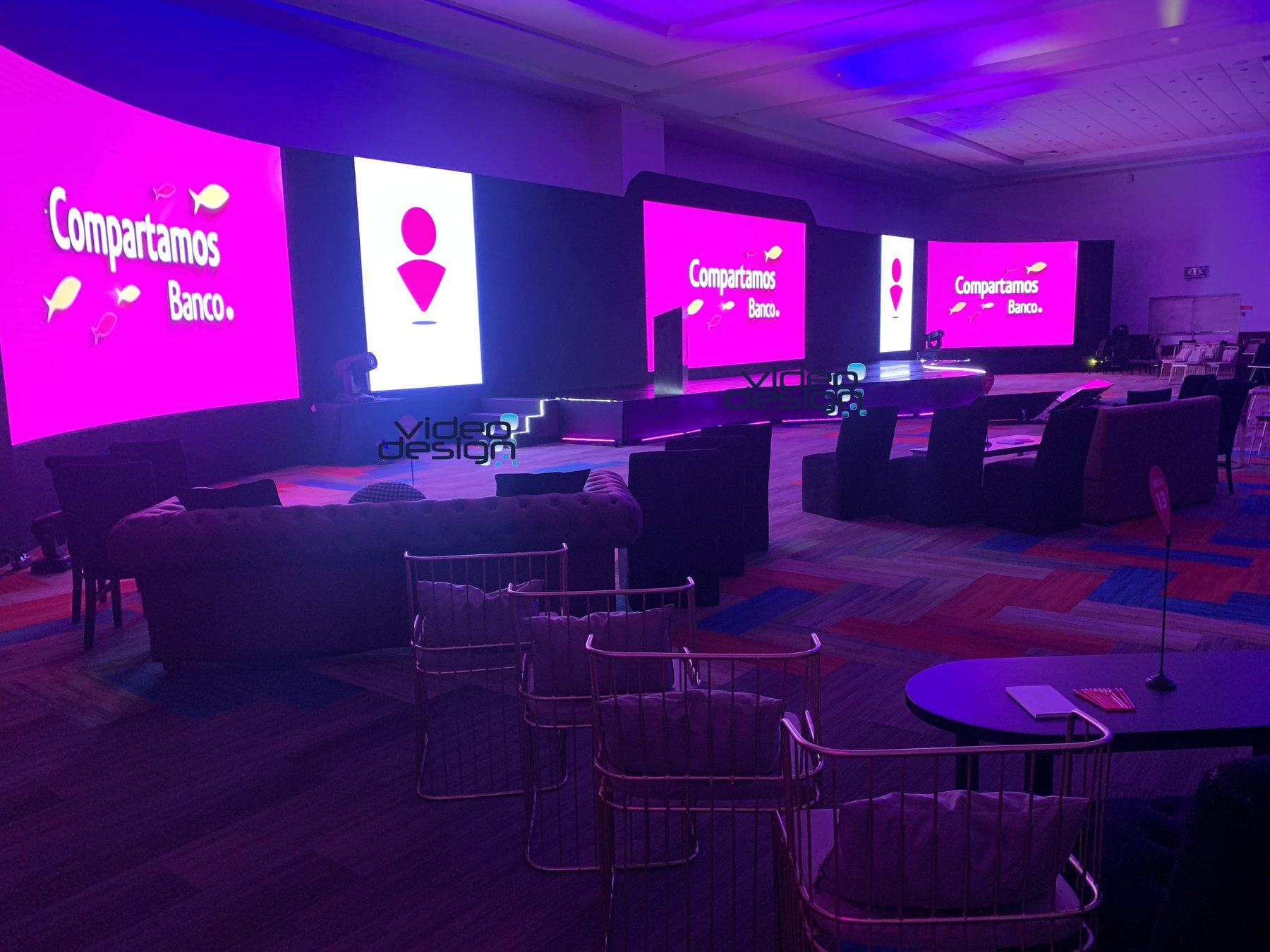 Escenario corporativo con pantalla LED panorámica, audio e iluminación producidos por VideoDesign
